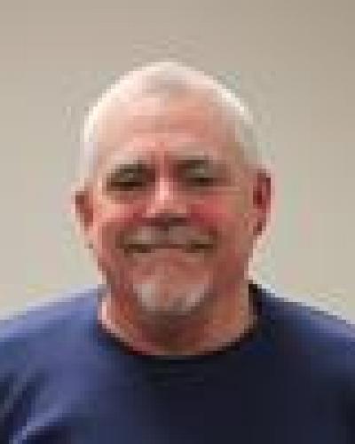 A man smiles and looks at the camera.